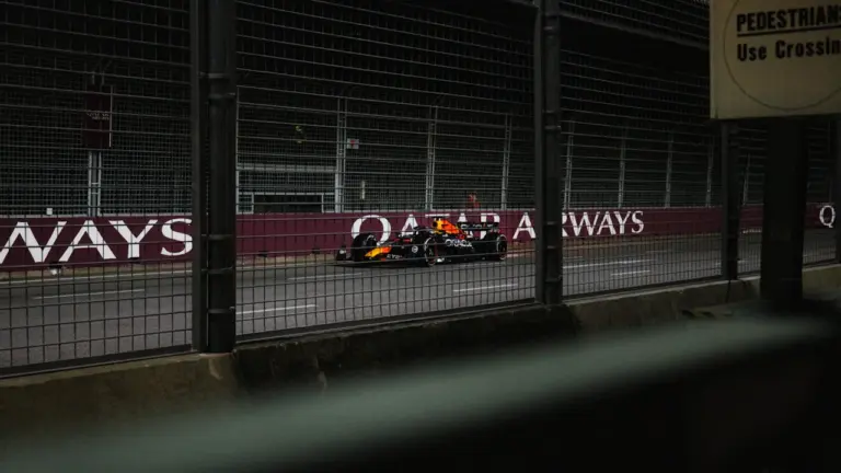Formula 1 sacīkšu auto ātrumā veic pagriezienu F1 trases norobežotajā posmā.