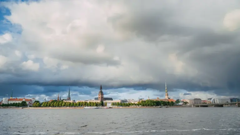 Daugavas upe un Rīgas panorāma zem dramatiski tumšiem negaisa mākoņiem vasaras dienā