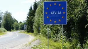 Latvijas valsts robežas zīme uz ceļa fona, kas simbolizē valsts ekonomisko un fiskālo atbildību.