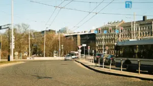 Ielas skats Rīgā ar automašīnām un sabiedrisko transportu pilsētas centrā.