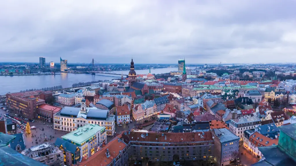 Panorāmas skats uz Rīgas vēsturisko centru un Daugavu saulainā dienā no baznīcas torņa.