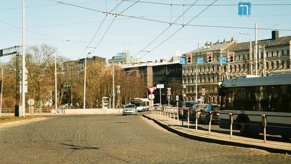 Autobuss un automašīnas uz Rīgas ielas septembra sākumā, gatavojoties ikdienas satiksmei.